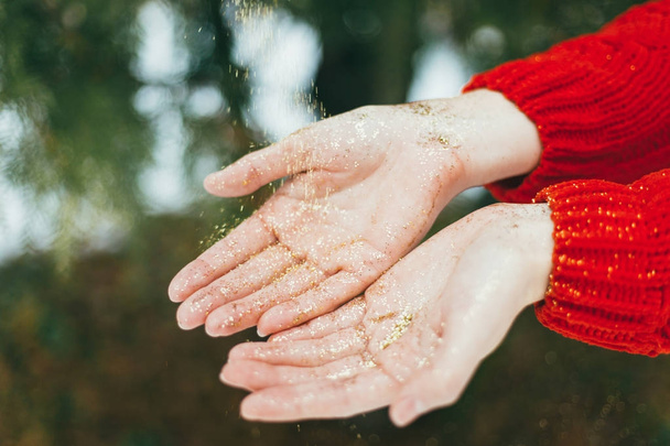 Golden glitter in hands - Φωτογραφία, εικόνα