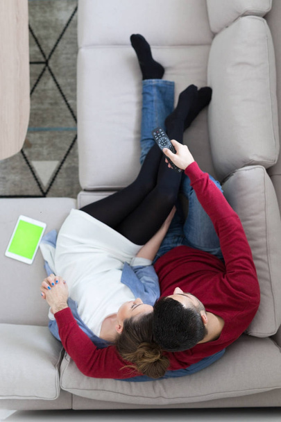 Young couple on the sofa watching television top view - Photo, image