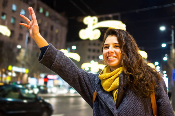 女性が都市環境でタクシーを呼んで - 写真・画像
