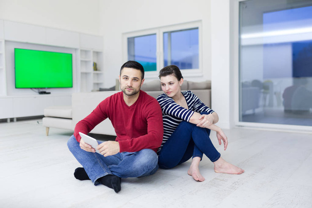 Νεαρό ζευγάρι χρησιμοποιώντας ψηφιακό tablet στο πάτωμα - Φωτογραφία, εικόνα