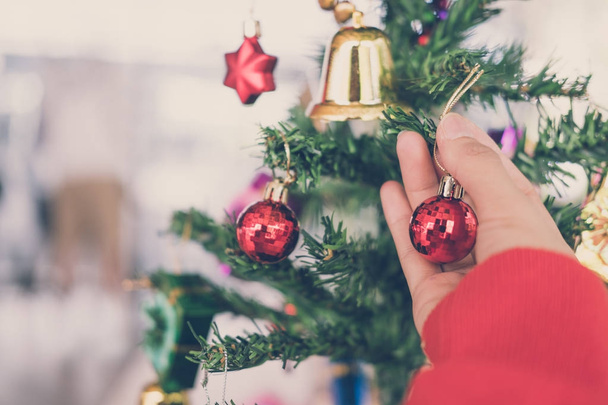žena držící vánoční ozdoba. dívka zdobit vánoční stromeček v h - Fotografie, Obrázek