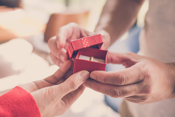 Erkek kadına nişan yüzüğüyle hediye kutusu veriyor. erkek arkadaş mak - Fotoğraf, Görsel