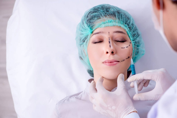 Plastisch chirurg bereidt zich voor op operatie op vrouw gezicht - Foto, afbeelding
