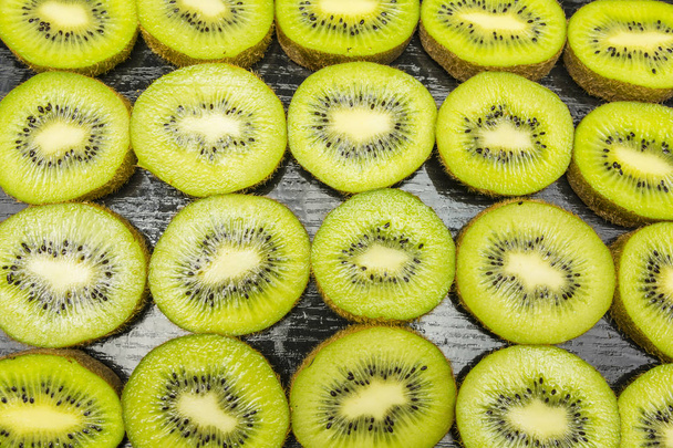 Kiwifrüchte in ein Muster oder eine Textur oder einen Hintergrund schneiden. - Foto, Bild