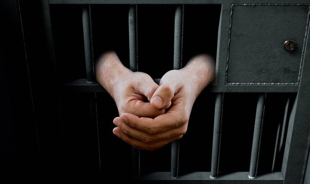 Gevangenis celdeur en handen - Foto, afbeelding