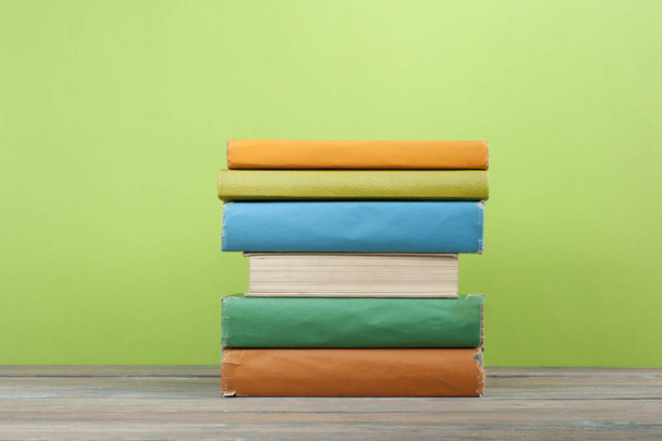 Stack of colorful books on the wooden table. Education background. Back to school. Copy space for text. - Фото, изображение