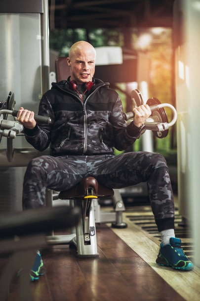 jeune homme beau en vêtements de sport faisant de l'exercice dans la salle de gym
 - Photo, image