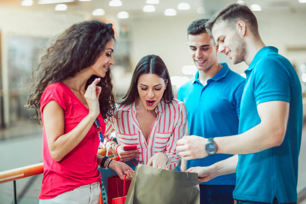 Grupa młodych przyjaciół z torby na zakupy w centrum handlowym razem - Zdjęcie, obraz