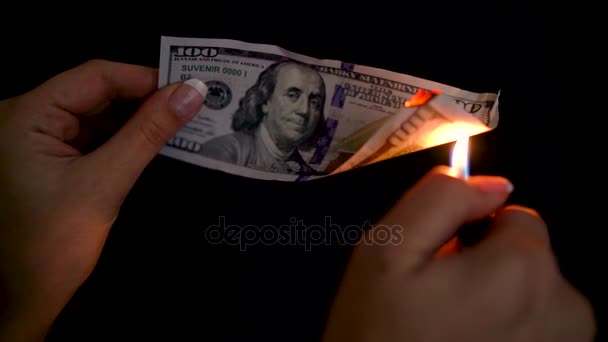 Burning dollars in a hand close-up on a black background. Slow motion - Footage, Video