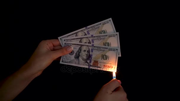 Burning dollars in a hand close-up on a black background - Video, Çekim
