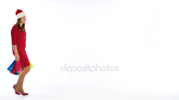 Christmas female shopper holding multicolored shopping bags on white background in studio. Lets go holiday shopping concept - Video