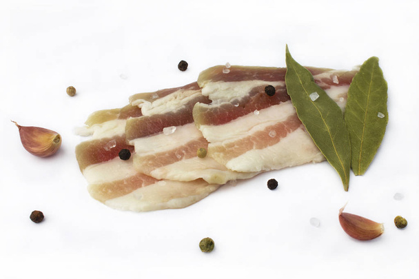 Fresh pork lard with spices on a white background. Sliced bacon. isolated  - Foto, Bild