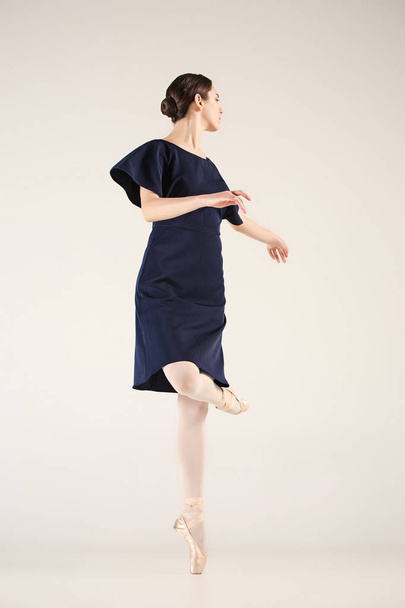 Young and incredibly beautiful ballerina is dancing in a blue studio - 写真・画像