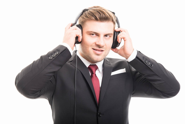 Young manager wearing suit putting on headphones - Photo, image