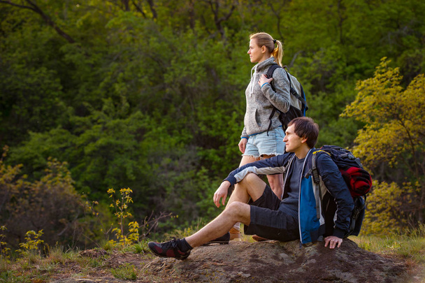 Couple of hikers relaxing during hiking. Travel, vacation, holidays and adventure concept. - Photo, Image