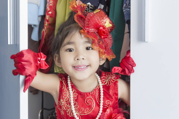 Aziatisch meisje aankleden in kledingkast - Foto, afbeelding