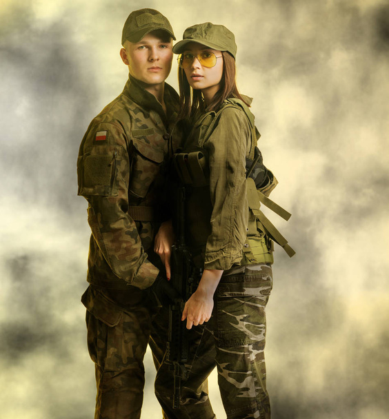Man en vrouw in militair kostuum op mistige achtergrond - Foto, afbeelding