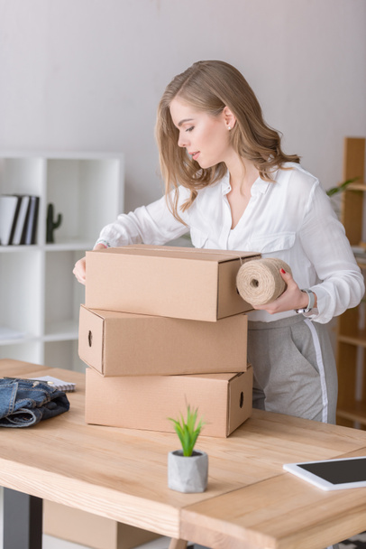 entrepreneur packing customers purchase in cardboard boxes at home office - Photo, Image