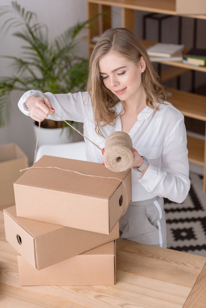 entrepreneur packing customers purchase in cardboard boxes at home office - Valokuva, kuva