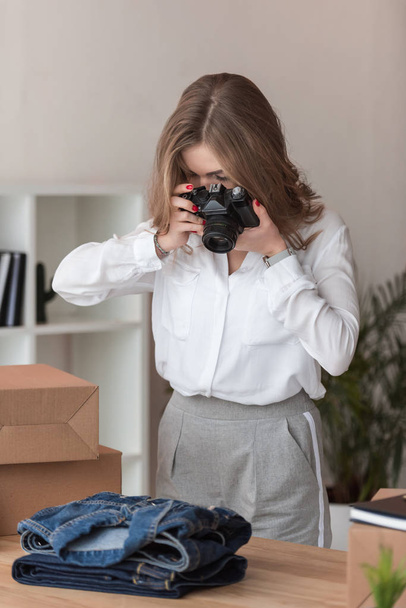 obscured view of self-employed businesswoman taking picture of products for customers at home office - Fotografie, Obrázek