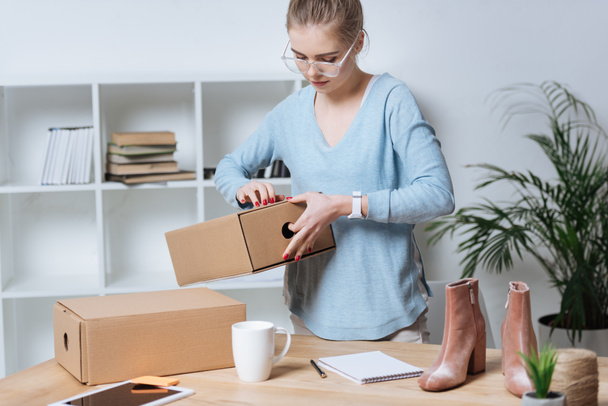 online shop proprietor with cardboard boxes working at home office - Photo, Image