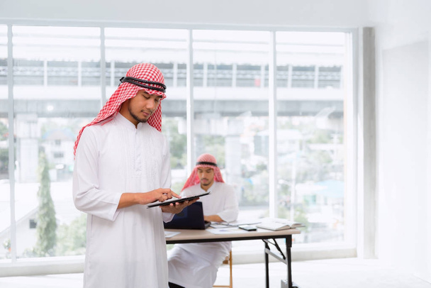 Empresarios árabes usando tableta y portátil
  - Foto, Imagen