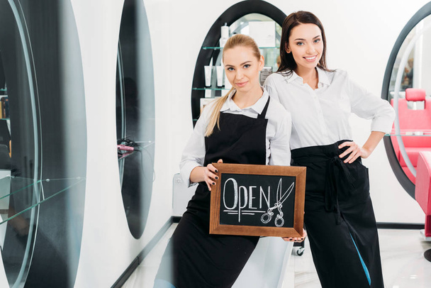 two beautiful hairdressers standing with sign open - Photo, Image