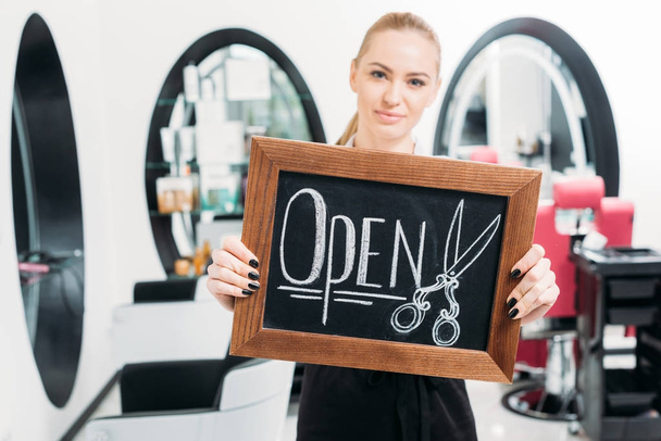 attractive hairdresser showing sign open - Foto, Imagem