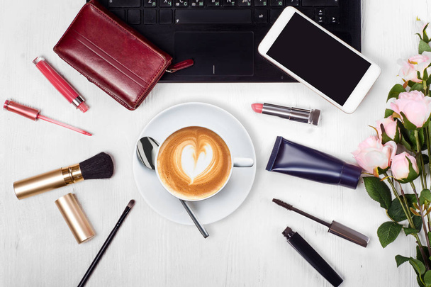 Cosmetics laptop cup of coffee cappuccino purse mobile phone smartphone flowers - Foto, afbeelding