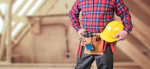 Travailleur du bâtiment avec ceinture à outils et casque
 - Photo, image