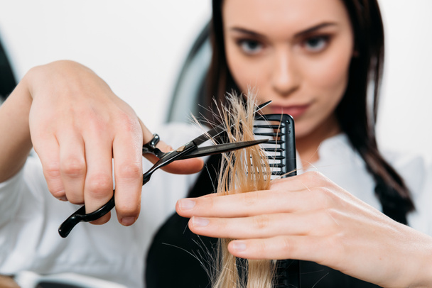 abgeschnittenes Bild des Friseurs, der Haarenden trimmt  - Foto, Bild