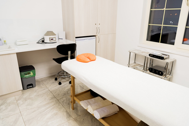 mesa de masaje vacía con almohada amarilla
 - Foto, Imagen