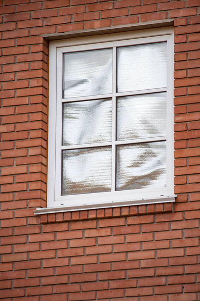Feuille dans la fenêtre de la brique rouge maison privée pour refléter le soleil d'été
 - Photo, image