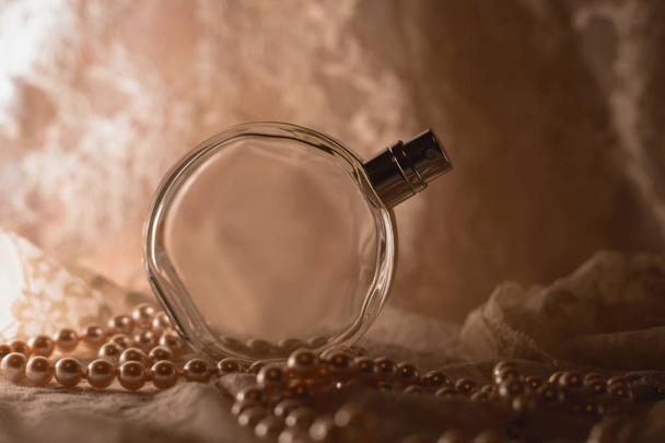 Flacon de parfum femme et collier de perles
 - Photo, image