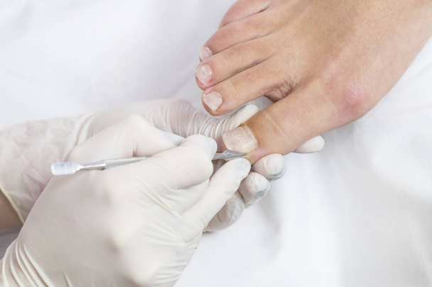 Female foot in the process of pedicure procedure in a beauty salon close-up. - Foto, Imagem
