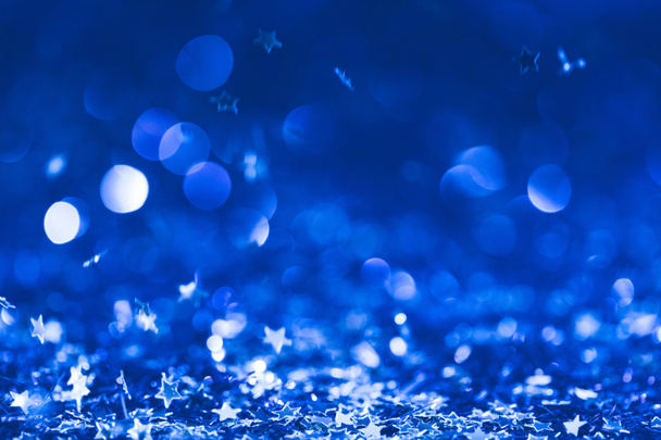 Χριστουγεννιάτικο φόντο με πτώση μπλε γυαλιστερά κομφετί αστέρια - Φωτογραφία, εικόνα