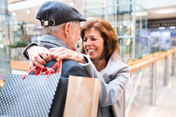 Senior couple doing Christmas shopping. - Zdjęcie, obraz