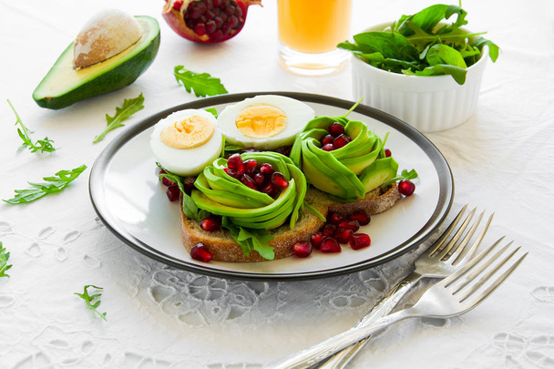 Avokado gül, haşlanmış yumurta ve beyaz masa örtüsü üzerinde taze salata ile tost - Fotoğraf, Görsel