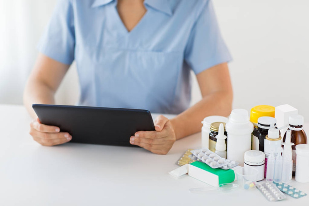 nurse or doctor with medicines and tablet pc - Фото, изображение