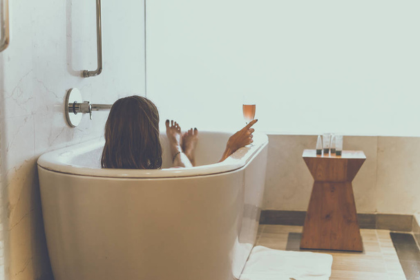Jovem mulher atraente com taça de champanhe relaxante no banho. Mulher sexy no banheiro. Spa feminino
. - Foto, Imagem
