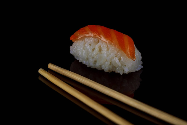 Lohisushia tai lohikaloja japanilaisen riisin päällä. Japanilaista ruokaa. musta tausta
 - Valokuva, kuva