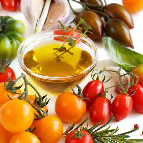 Kleurrijke tomaten, knoflook, basilicum en oilve olie  - Foto, afbeelding