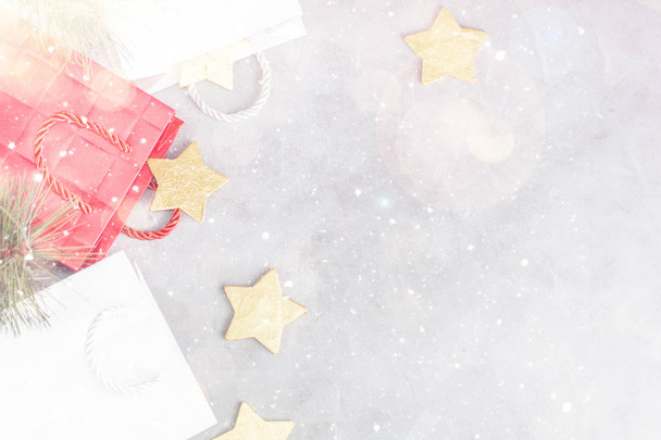 Fundo de Natal: sacos de compras, caixas de presente e estrelas de ouro sob a neve. Conceito de ano novo. Espaço de texto
 - Foto, Imagem
