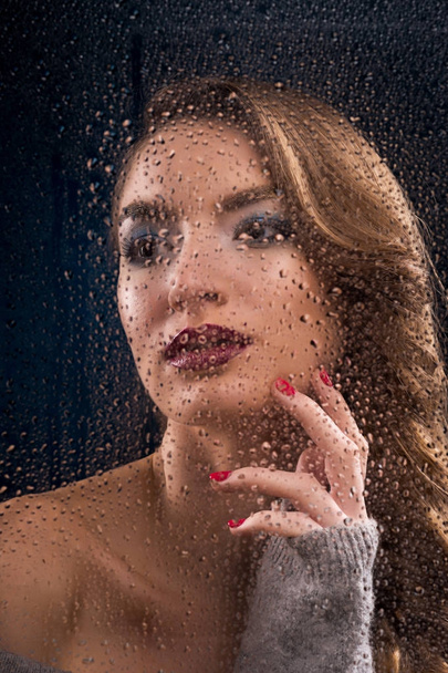 Gyönyörű lány visel érinti nedves ablaküveg. - Fotó, kép