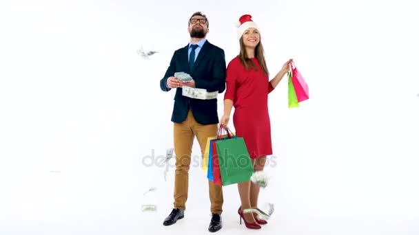 Dólares caindo em homem e mulher formalmente vestidos com o chapéu de Papai Noel. Vamos fazer compras de férias e celebrar o conceito
. - Filmagem, Vídeo