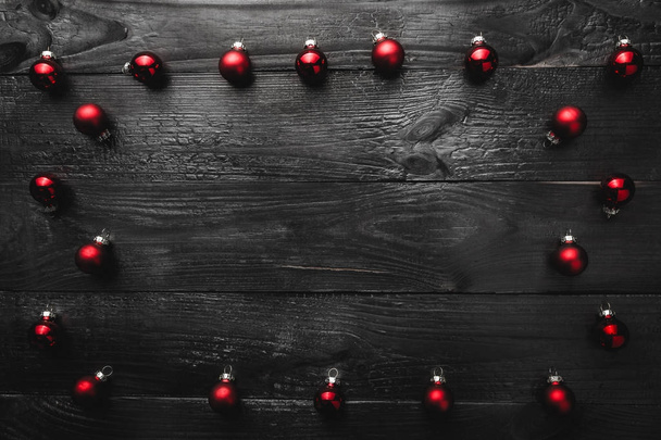 Верхний, верхний, вид сверху, вечнозеленые красные игрушки на черном деревянном фоне, с местом для написания текста, приветствие
. - Фото, изображение