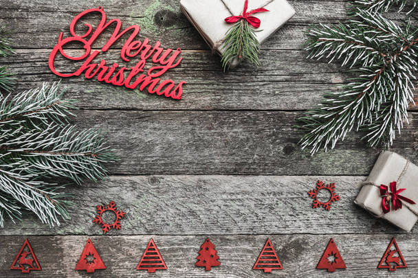 Felső, top, Nézd a fenti téli figurák, örökzöld ág, a jelen box és a piros boldog karácsonyt felirat szürke háttér, a hely a szöveg írása, üdvözlés. - Fotó, kép
