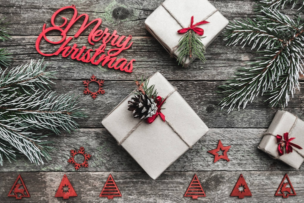 冬の置物、常緑の枝、プレゼント ボックス、テキストを書いて、ご挨拶用のスペースと、灰色の背景に赤のメリー クリスマス碑文の上から上、上を表示します。. - 写真・画像