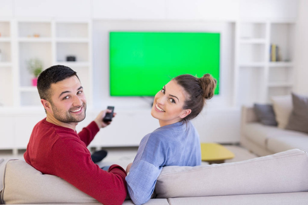 Young couple on the sofa watching television - Φωτογραφία, εικόνα