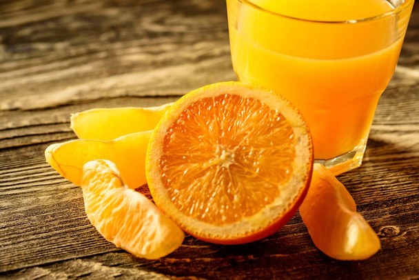 апельсини та апельсиновий сік на дерев'яному фоні
 - Фото, зображення